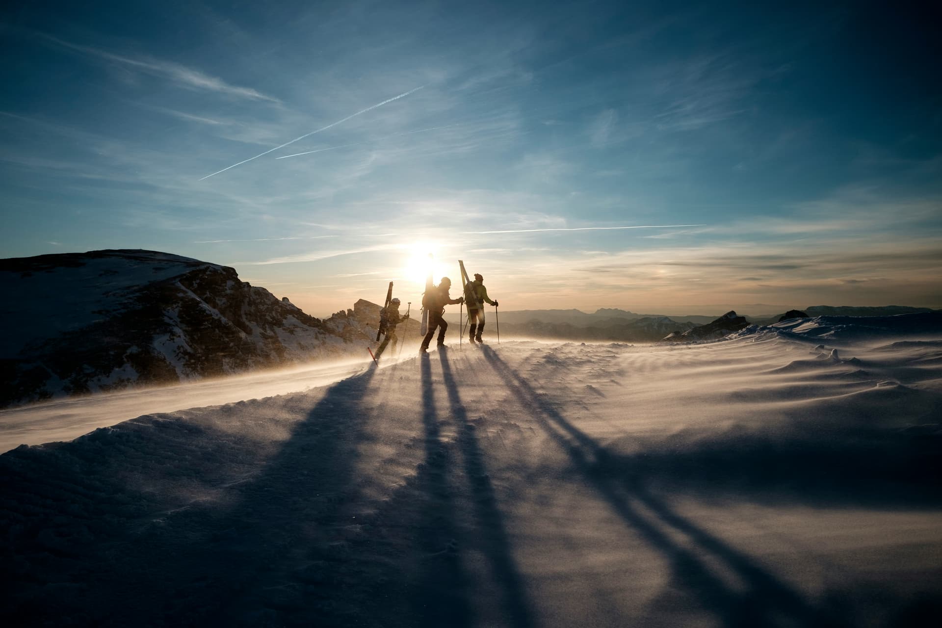 Skiers at sunrise in the mountains